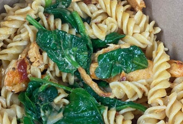 Pasta box Cajun chicken with spinach and cheese.
