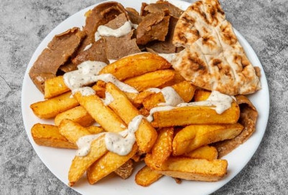 Lamb served with chips pitta bread sallad and tzatziki dip