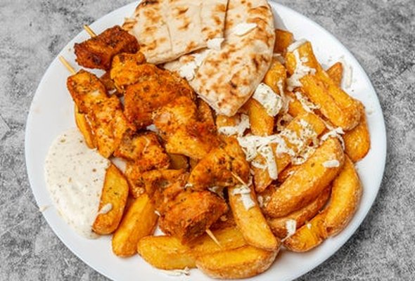 Chicken souvlaki served with chips pitta bread sallad and tzatziki dip