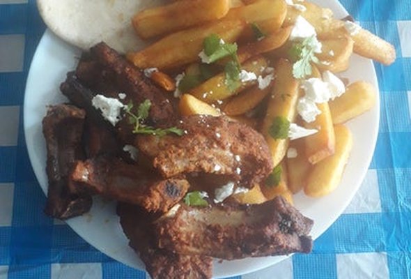 Ribs served with chips pitta bread sallad and tzatziki dip