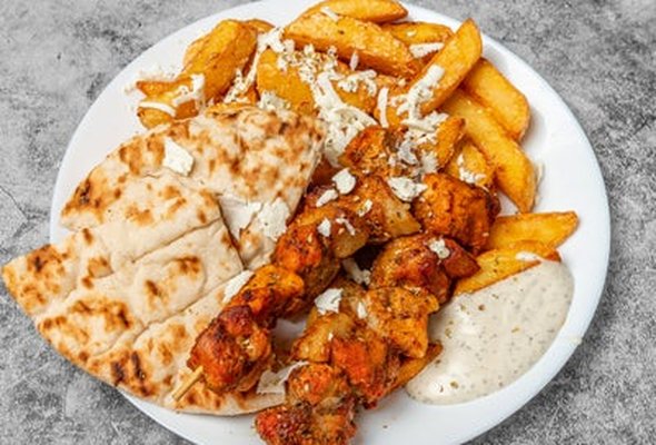 Pork souvlaki served with chips salad pitta bread and tzatziki dip