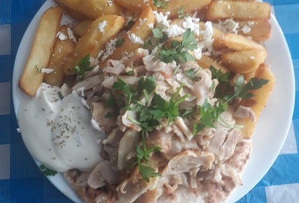 Pork served with chips pitta bread sallad and tzatziki dip